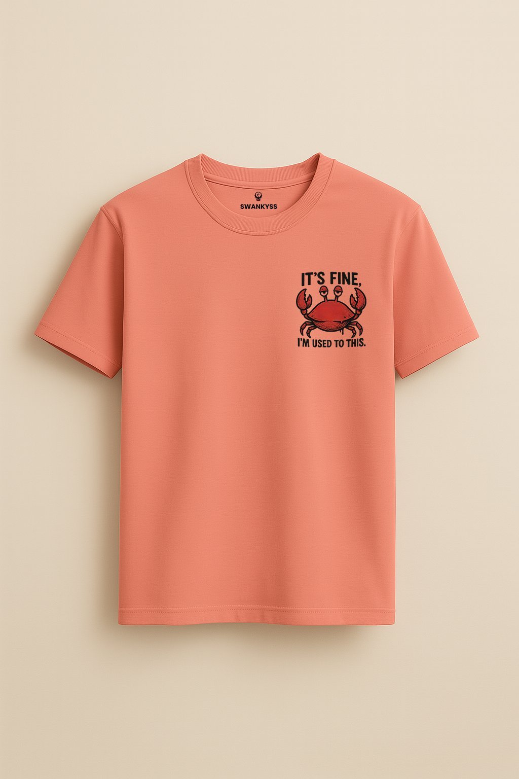 compressed-swankyss-funny-crab Peach unisex t-shirt with a cartoon crab and sarcastic quote "It’s Fine, I’m Used to This" – funny relatable graphic tee front view
