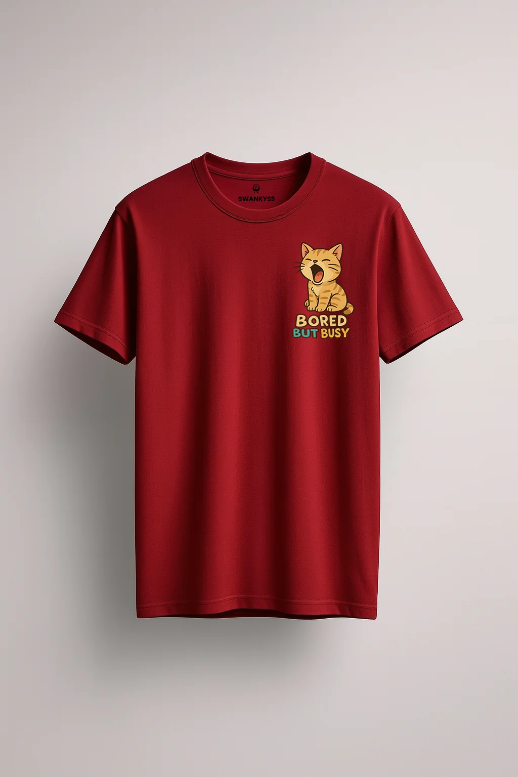 compressed_bored_cat_tshirt Unisex maroon cotton T-shirt with a yawning cartoon cat and the text "Bored But Busy" printed on the chest, featuring a regular fit, round neck, and short sleeves front view