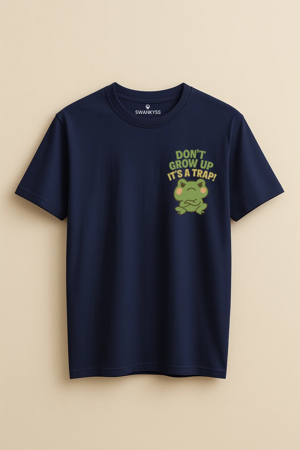 dont_grow_up_tshirt_under_1000kb Navy blue unisex t-shirt featuring a grumpy cartoon frog and the humorous quote “Don’t Grow Up, It’s a Trap!” – casual funny tee by Swankyss front view