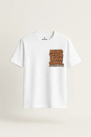 White unisex t-shirt with bold brown text that reads “Mind Your Own Game” and a coffee cup icon – sarcastic and funny quote graphic tee by Swankyss front view