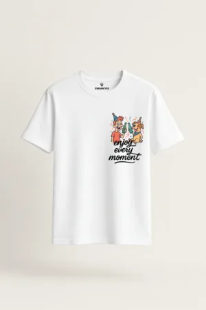 White unisex t-shirt with cartoon of a man and a dog wearing party hats, clinking drinks, and quote “Enjoy Every Moment” – Swankyss fun celebration graphic tee front view
