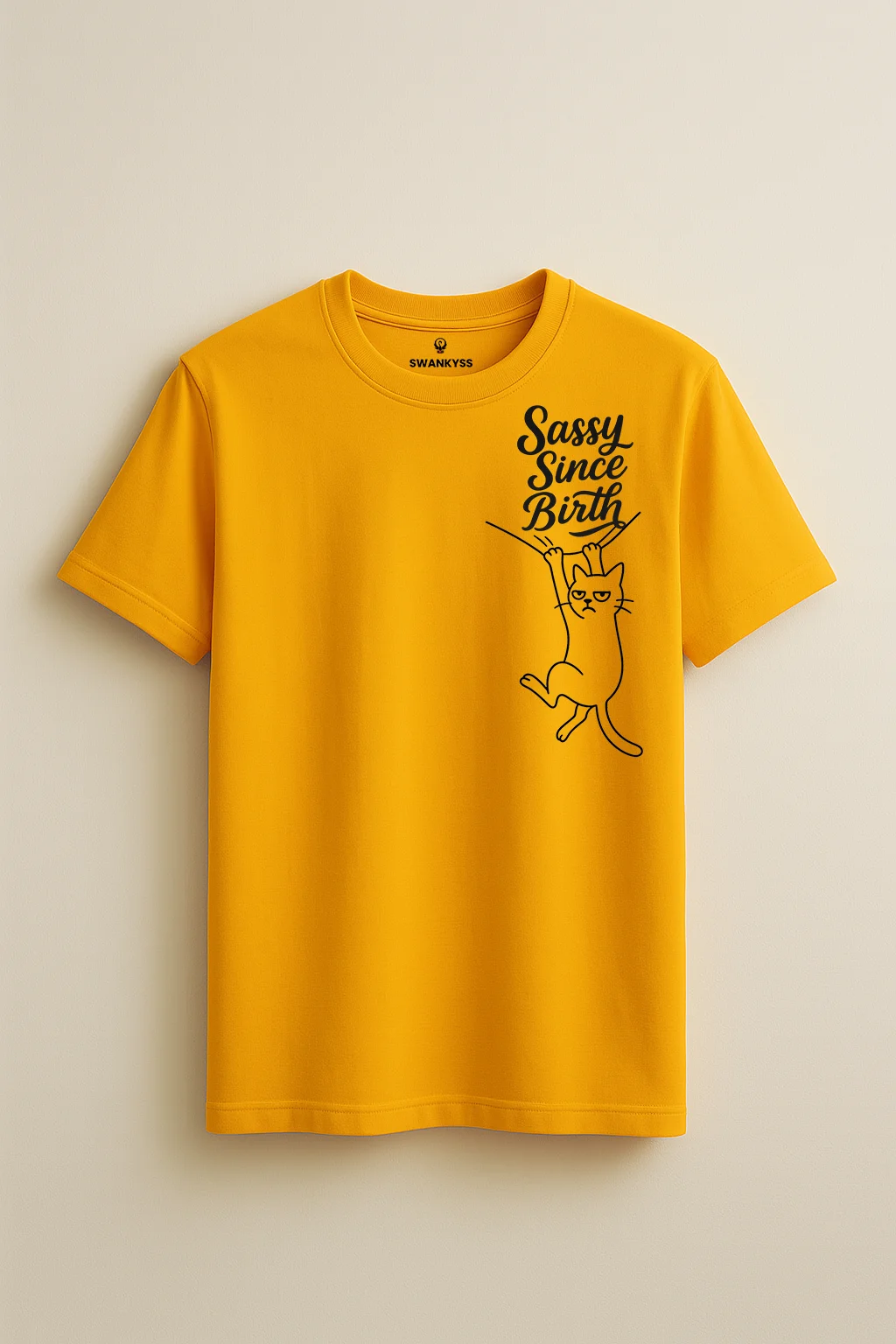 sassy_since_birth_tshirt_under_1000kb Mustard yellow unisex t-shirt with a minimal black line art cat hanging from a wire and “Sassy Since Birth” quote – funny and confident attitude tee by Swankyss front view