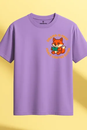 Lavender t-shirt featuring a cartoon orange fox holding money with the quote "Drama is Free, Peace Costs Extra" in bold orange letters front view